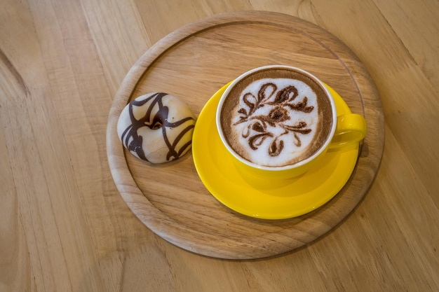 Café em xícara amarela na mesa de madeira