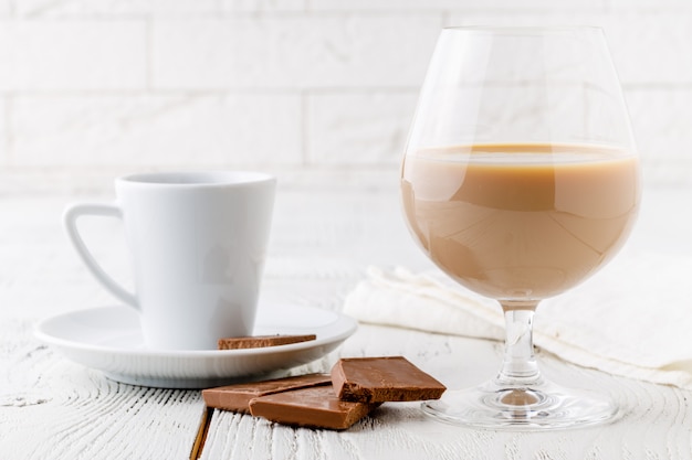 Café em xícara de cerâmica branca e pedaços de chocolate