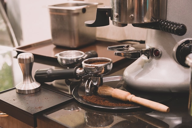 Café esmerilado y pisón y herramientas de café para la máquina de café en una cafetería