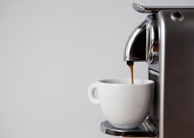 Foto café espresso que vierte de la máquina de café