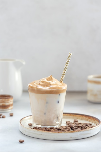 Café con espuma dulce y hielo en un vaso.