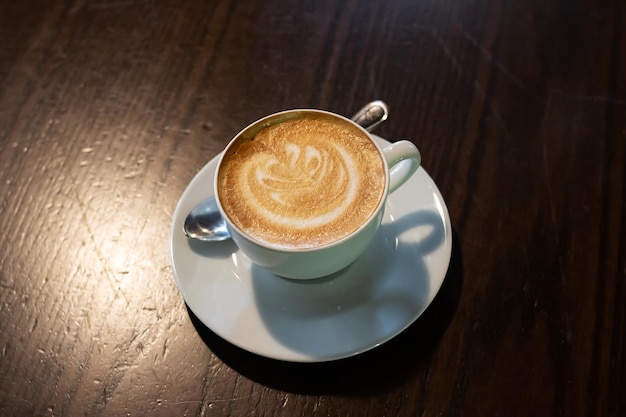 Café con espuma sobre la mesa en la oscuridad