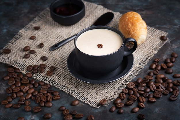 Café expreso y croissants para el diseño plano del desayuno con una vista desde arriba de los granos de café