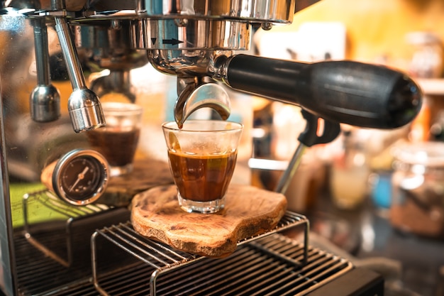 El café expreso fluye hacia la taza de chupito.