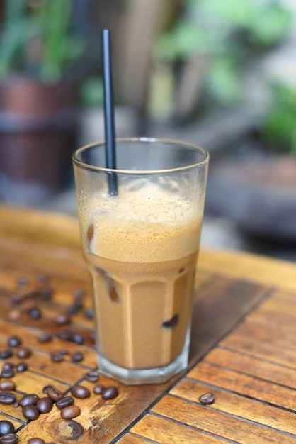 Café expresso de leite gelado com grãos de café na mesa de madeira closeup