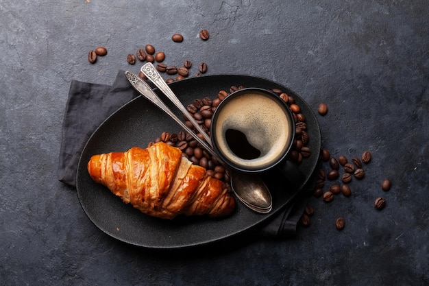 Café expresso e croissant para o pequeno-almoço