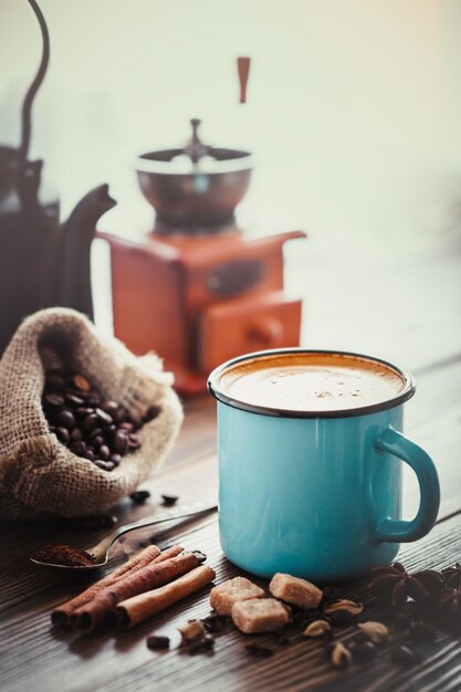 Café expresso em xícara esmaltada azul cubos de açúcar saco de grãos de café especiarias moinho de café