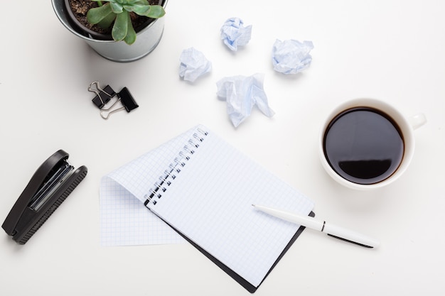 Café, folhas de papel e wads amassados na mesa