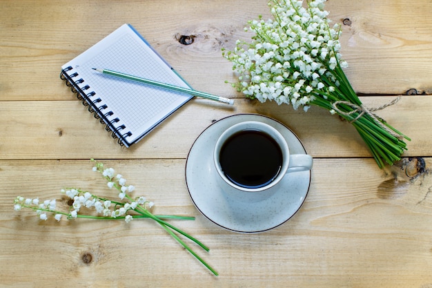 Foto café en un fondo de madera y flores.