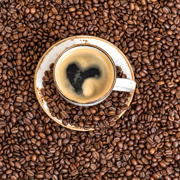 Foto café con forma de corazón. fondo de granos de café. concepto de amor