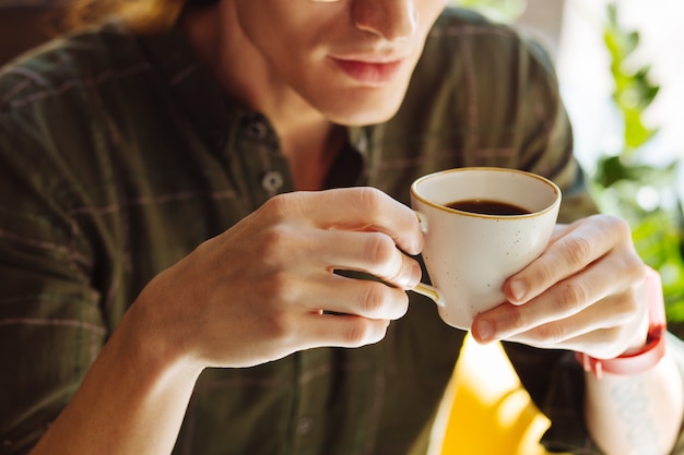 Café forte. Perto de uma xícara com café forte enquanto está em mãos masculinas