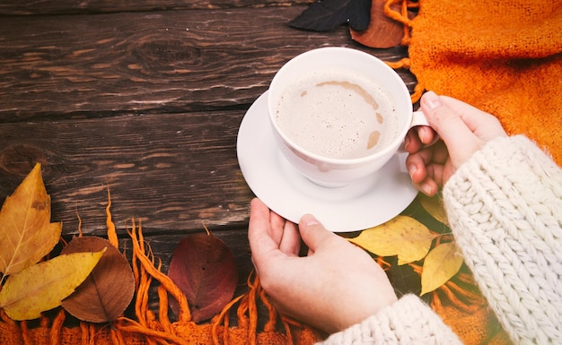 café fragante en tus manos contra el fondo del otoño