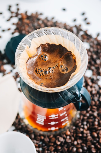 Café fresco em uma xícara usando o método alternativo, com derramamento sobre o gotejador e filtro de papel.