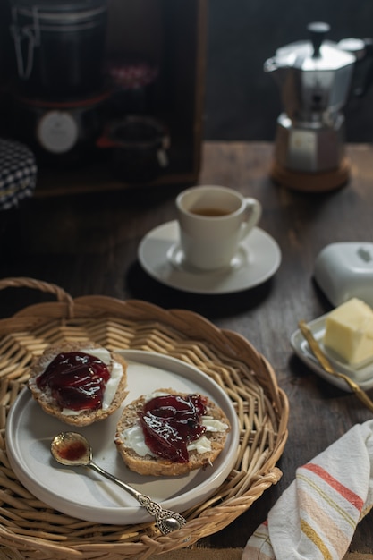 Café fumegante e pão torrado com manteiga e marmelada