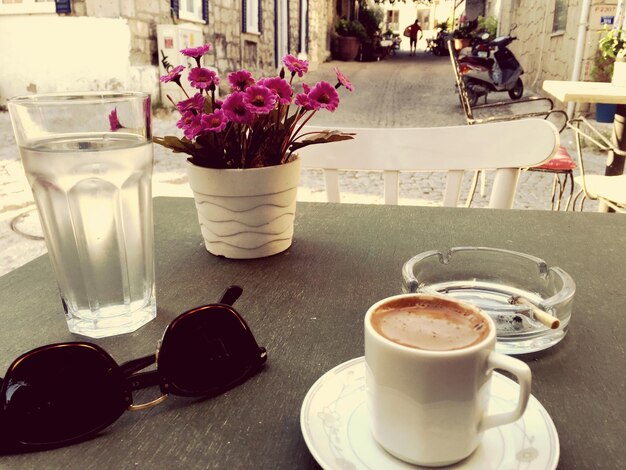 Foto café con gafas de sol en la mesa en la cafetería de la acera