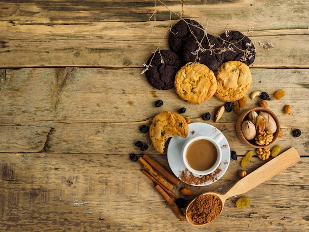 Café y galletas en una mesa de madera. Espacio para texto sobre la mesa.