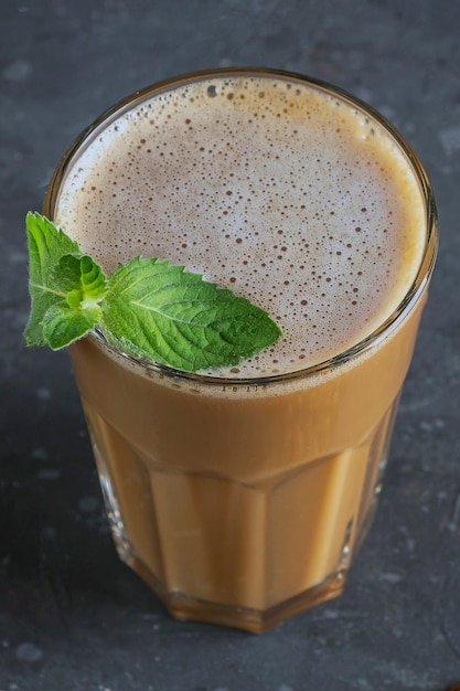 Café gelado com hortelã e leite. Copo grande de coquetel de café. Bebida refrescante de verão fresco em fundo escuro na chave de lei. copie o espaço para o texto.