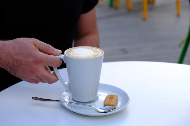 Café gelado com leite. Café com leite gelado. Mulher segurando o copo de café gelado.