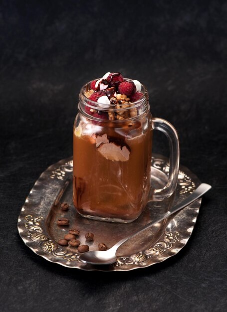 Café gelado com sorvete de chocolate e framboesas no prato vintage