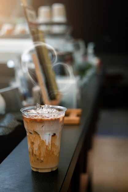 Café gelado em um copo de plástico com creme sendo derramado mostrando a textura