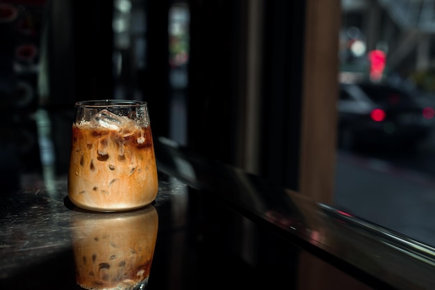 Café gelado em uma mesa com creme sendo derramado mostrando a textura e a aparência refrescante do