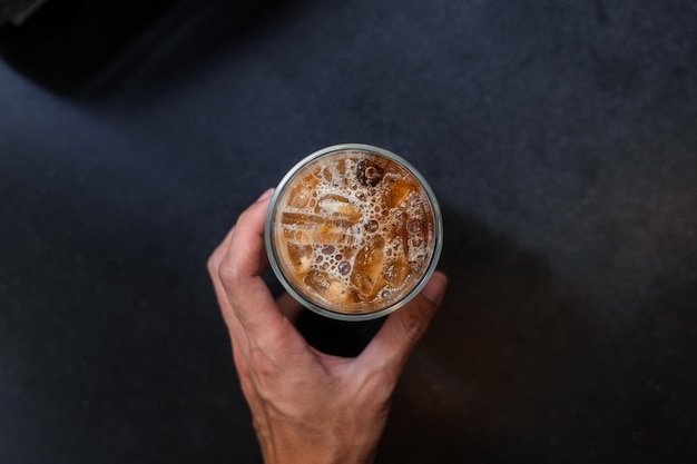 Café gelado em uma mesa com creme sendo derramado mostrando a textura e a aparência refrescante do