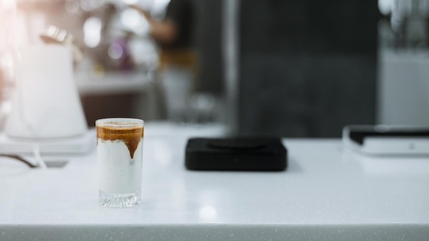 Café gelado em uma mesa com creme sendo derramado mostrando a textura e a aparência refrescante do