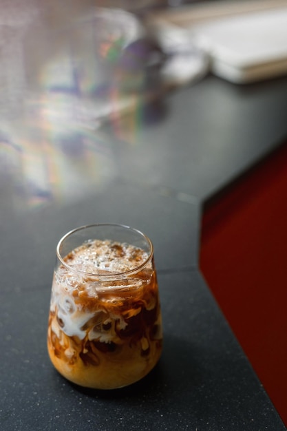 Café gelado em uma mesa com creme sendo derramado mostrando a textura