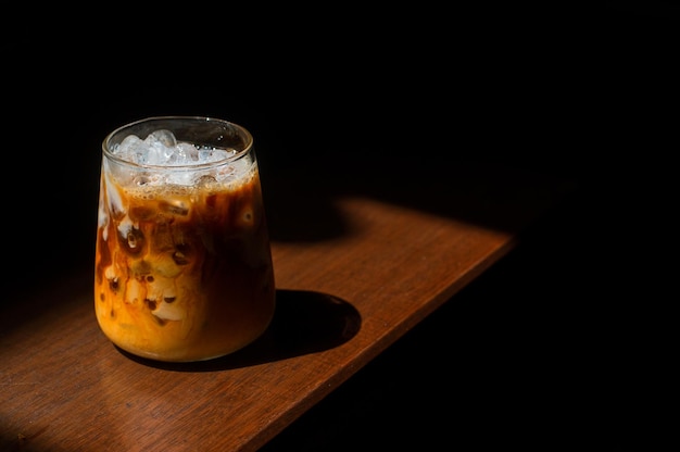 Café gelado em uma mesa de madeira com creme sendo derramado mostrando a textura