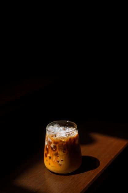 Café gelado em uma mesa de madeira com creme sendo derramado mostrando a textura