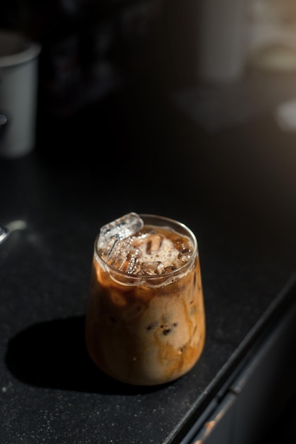 Café gelado em uma mesa preta com creme sendo derramado mostrando a textura