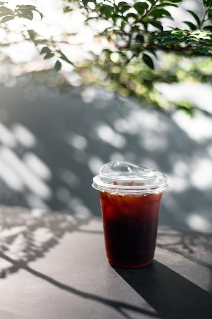 café gelado em vidro plástico na mesa preta