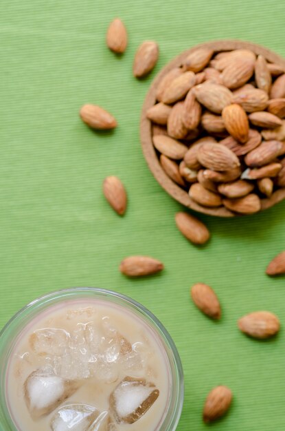 Café helado y desenfoque de almendras sobre fondo verde