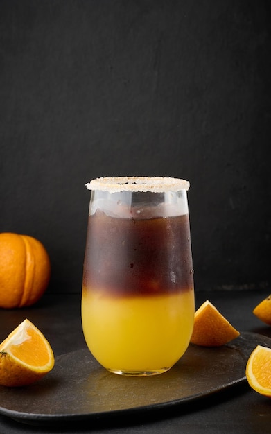 Café helado con jugo de naranja en un vaso transparente refrescante café bumble sobre la mesa