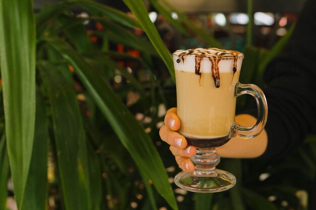 Café helado con leche Café con leche helado Mujer sosteniendo una taza de café helado