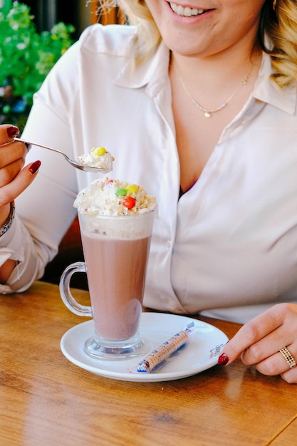 Café helado con leche. Café con leche helado. Mujer sosteniendo una taza de café helado.