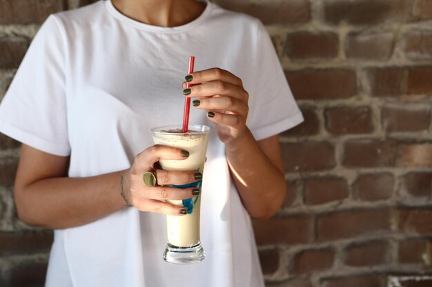 Café helado con leche Café con leche helado Mujer sosteniendo una taza de café helado