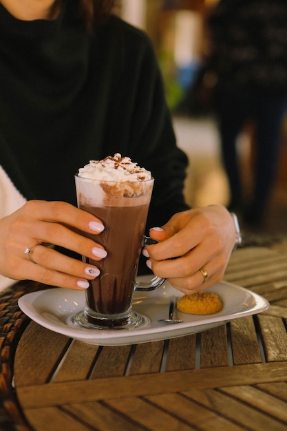 Café helado con leche. Café con leche helado. Mujer sosteniendo una taza de café helado.