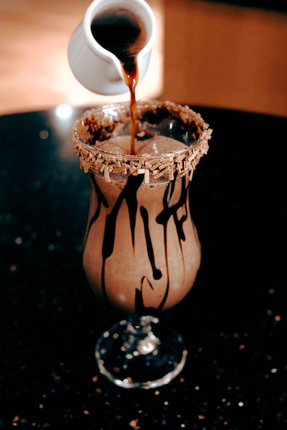 Café helado con leche. Café con leche helado. Mujer sosteniendo una taza de café helado.