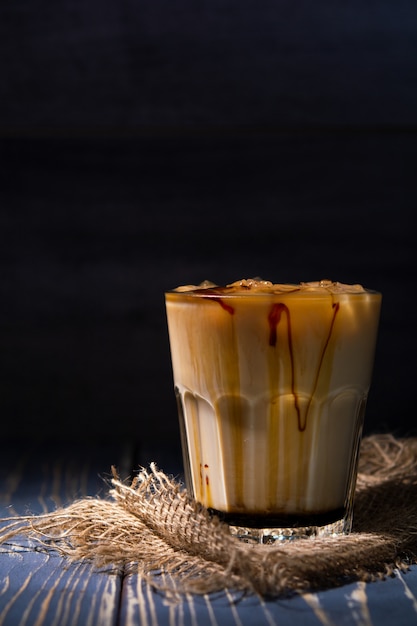 Café helado con leche en la pared oscura