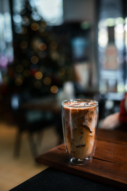 Café helado con leche servido en la mesa negra en un café fondo de vacaciones de Navidad