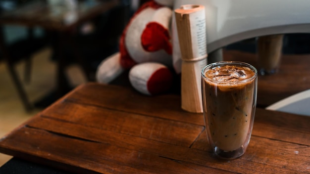 Café helado con leche servido en la mesa negra en un café fondo de vacaciones de Navidad