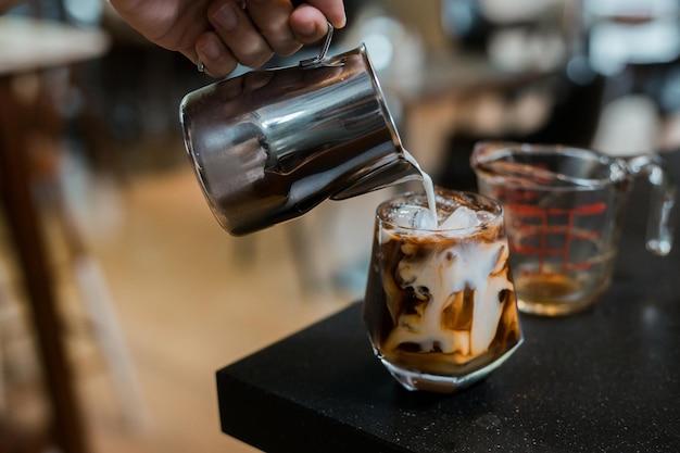 Café helado con leche servido en la mesa negra en un café