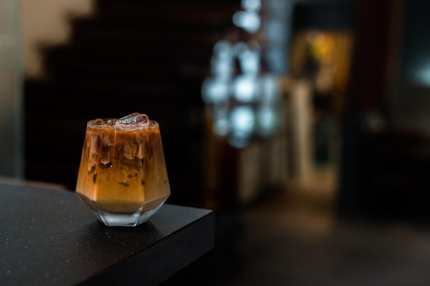 café helado con leche servido en la mesa negra de un café