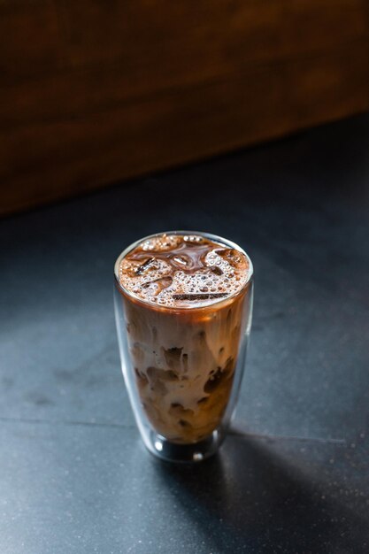 café helado con leche servido en la mesa negra de un café