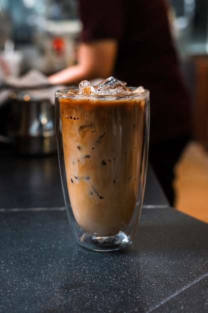 café helado con leche servido en la mesa negra de un café