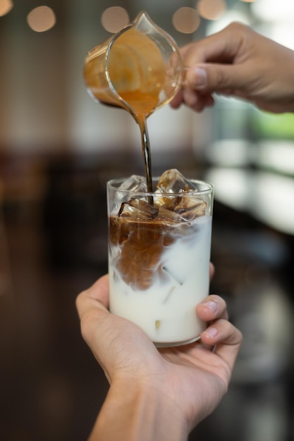 Foto café helado con leche en un vaso sobre una mesa en un café