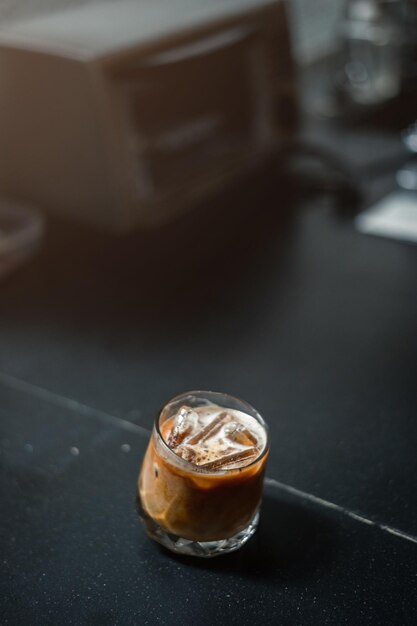 Café helado en una mesa con crema que se vierte mostrando la textura y el aspecto refrescante del