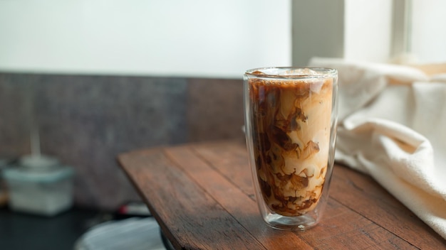 Café helado en la mesa con crema que se vierte mostrando la textura