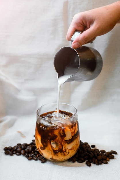 Café helado en una mesa con crema que se vierte mostrando la textura